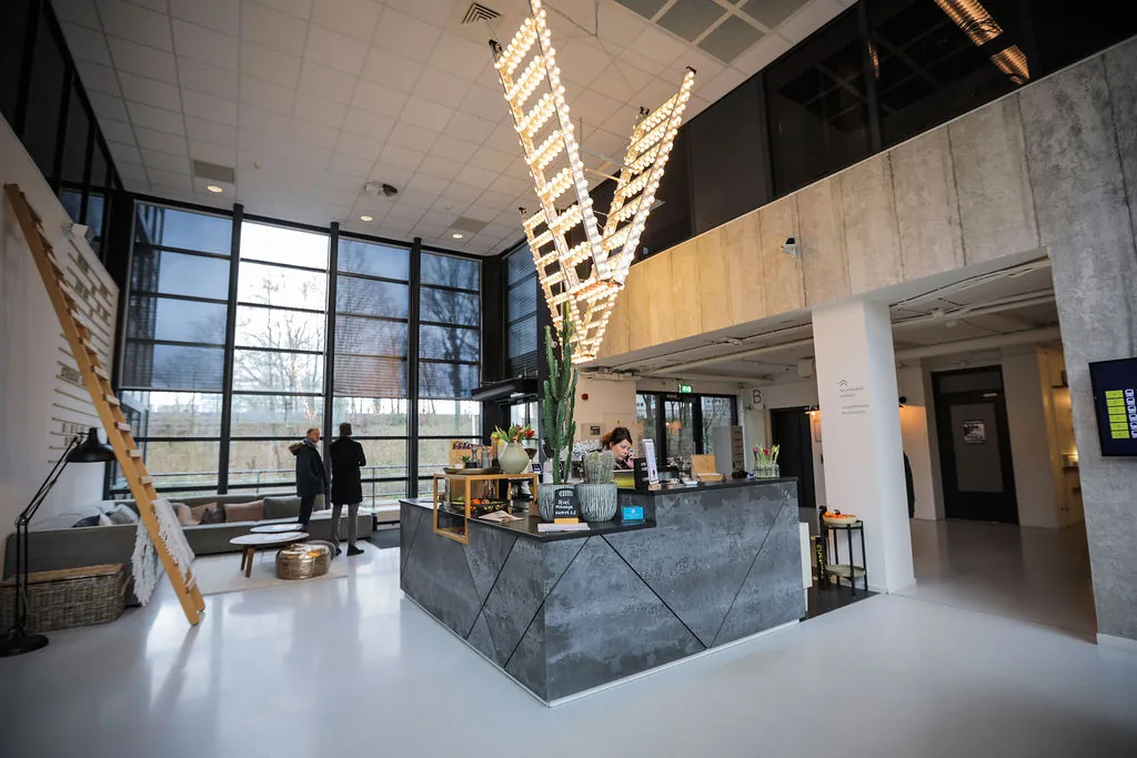 Moderne receptieruimte aan de Marten Meesweg met een strak design, grote raampartijen en opvallende verlichting.